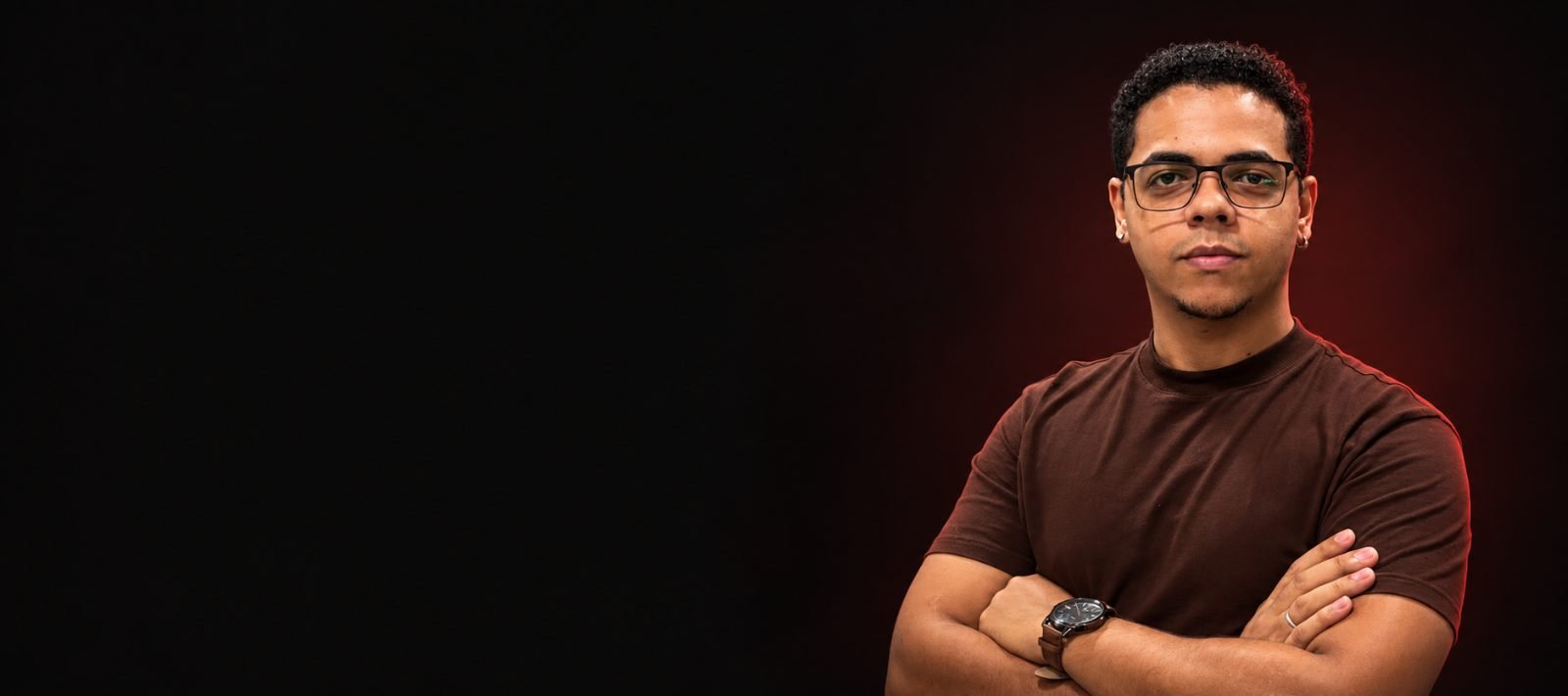 Heisemberg Almeida, CEO da Social Play, de braços cruzados sobre fundo escuro com luz vermelha